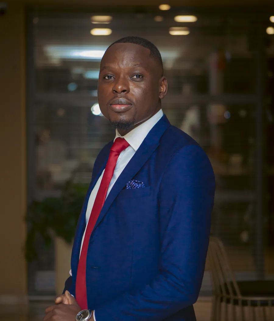 Patrick Kabemba in a navy suit and red tie
